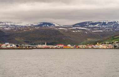 İzlanda 'daki dağların ve denizin dramatik manzarası, Isafjordur kasabasının yolcu gemisi limana yaklaşırken.