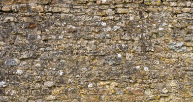 İngiliz Ortaçağ şatosundaki yıpranmış taş bir duvara yakın plan mükemmel bir zemin oluşturmak için eskimiş ve aşınmış.