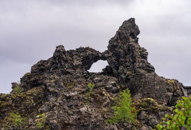 Myvatn Gölü yakınlarındaki Dimmuborgir 'de eşsiz volkanik kaya oluşumları ve oyuk sütunlar İzlanda manzaralarının jeolojisini gözler önüne seriyor.
