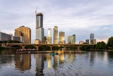 Austin, TX - 13 Ağustos 2025: Austin TX 'in ufuk çizgisindeki Lady Bird Gölü üzerinde tur teknesi ile yeni inşaat kuleleri
