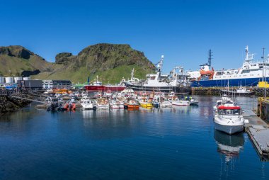 Heimaey, İzlanda - 31 Mayıs 2025: Küçük tekneler ve büyük balıkçı tekneleri Vestmannaeyjar limanına yanaştı