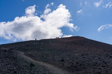 Uzun yürüyüşçüler 1973 'te Heimaey Adası' nda patlayan yanardağ Eldfell kraterinin etrafındaki lava tırmanıyor.