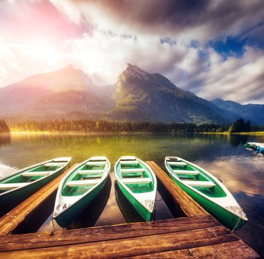 Güneş ışığı altında parlayan ahşap iskelenin muhteşem manzarası. Dramatik ve resimli bir sahne. Ünlü tatil beldesi Berchtesgadener Land, Hintersee, Bavyera Alpleri. Avrupa. Güzellik dünyası.
