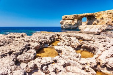 Güneşli bir günde mavi gökyüzü ile kayalık sahilin muhteşem manzarası. Resimli ve muhteşem bir sahne. Ünlü yer Azure Pencere, Gozo Adası, Dwejra. Malta. Avrupa. Akdeniz 'de. Güzellik dünyası.
