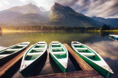 Güneş ışığı altında parlayan ahşap iskelenin muhteşem manzarası. Dramatik ve resimli bir sahne. Ünlü tatil beldesi Berchtesgadener Land, Hintersee, Bavyera Alpleri. Avrupa. Güzellik dünyası.