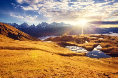 Koruldi Gölü 'nün altında bulutlu bir gökyüzü var. Ushba. Dramatik sabah sahnesi. Yukarı Svaneti, Mestia, Gürcistan, Avrupa. Yüksek Kafkasya sırtı. Sıcak tonlama etkisi. Güzellik dünyası.