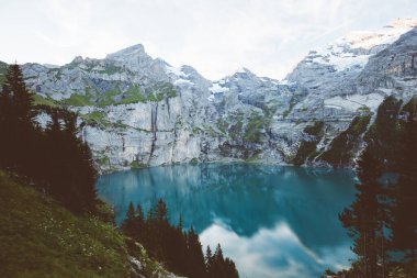 Buzul göleti Oeschinensee. Popüler turist eğlencesi. Resimli ve muhteşem bir sahne. İsviçre Alpleri, Kandersteg, Bernese Oberland, Avrupa. Bağbozumu etkisi. Instagram filtrelenmiş. Güzellik dünyası.