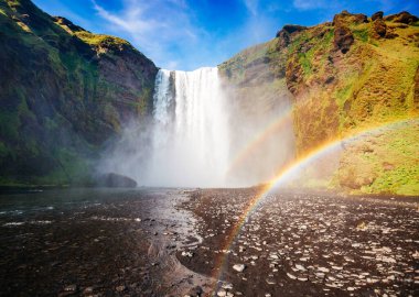Skogafoss şelalesinin ve manzaranın harika manzarası. Dramatik ve resimli bir sahne. Popüler turist eğlencesi. Konumu ünlü yer Skoga nehri, İzlanda, Avrupa 'nın dağlık bölgeleri. Güzellik dünyası.