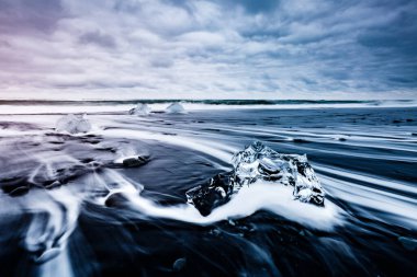 Siyah kumda parlayan buzdağının büyük parçaları. Popüler turist eğlencesi. Ünlü mekan Jokulsarlon lagünü, Vatnajokull Ulusal Parkı, İzlanda, Avrupa. Güzellik dünyası.