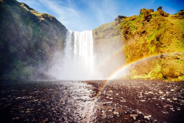 Skogafoss şelalesinin ve manzaranın harika manzarası. Dramatik ve resimli bir sahne. Popüler turist eğlencesi. Konumu ünlü yer Skoga nehri, İzlanda, Avrupa 'nın dağlık bölgeleri. Güzellik dünyası.