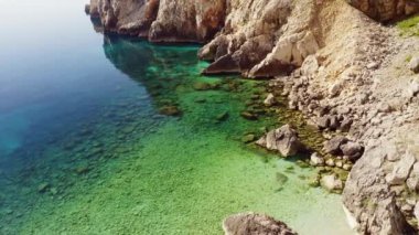 Güneşli bir günde gök mavisi turkuaz göl koyunda İHA uçuşu. Kvarner Körfezi, Losinj Adası, Veli Losinj, Hırvatistan kıyısı, Avrupa. Popüler turizm merkezi. Toprağın güzelliği. Hava atışı, 4K.