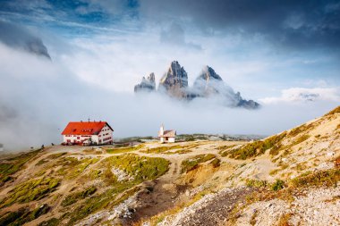 Rifugio Locatelli ile Tre Cime di Lavaredo Ulusal Parkı 'nın sisli manzarası. Dramatik ve muhteşem bir sahne. Yeri Dolomiti Alpleri, Tyrol, İtalya, Avrupa. Popüler turist eğlencesi. Güzellik dünyası.