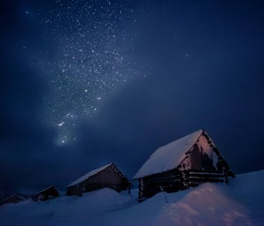 Yıldızlı gökyüzüne ve dağ yamacındaki eski eve bakın. Dramatik ve resimli bir sahne. Mekan Karpatlar, Ukrayna, Avrupa. Güzellik dünyasını keşfedin. Sanatsal resim. Astrofotoğrafçılık.