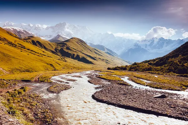 Shkhara buzulunun eteğindeki hızlı nehir. Resimli ve muhteşem bir sahne. Yeri Svaneti, Mestia, Gürcistan, Avrupa. Yüksek Kafkasya sırtı. Bağbozumu etkisi. Instagram filtrelenmiş. Güzellik dünyası.
