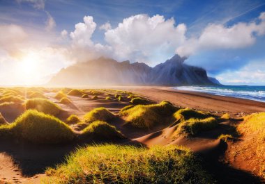 Güneşli bir günde Stoksnes pelerininin manzarası çok etkileyici. Yeri Vestrahorn (Batman Dağı), İzlanda, Avrupa. Popüler turistik cazibenin manzarası. Seyahat güzergahı. Toprağın güzelliğini keşfedin.