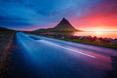 Akşam Kirkjufell volkanı Snaefellsnes yarımadasının kıyısında. Kirkjulsfoss 'un yeri. Tipik İzlanda manzarası. İklim değişikliği. Duvar kağıdının harika bir görüntüsü. Dünyanın güzelliğini keşfedin.