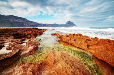 Güneş ışığındaki volkanik plajın eşsiz şekli. Resimli bir gün ve muhteşem bir sahne. Açık hava aktivitesi. Mekan San Vito Burnu, Monte Cofano Sicilya, İtalya Avrupa. Dünyanın güzelliğini keşfedin.