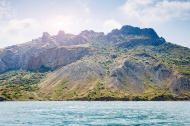 Kırım Yarımadası 'ndaki resim gibi bir dağ sırası, sönmüş antik bir volkan. Kara Dag (Black Mount), Koktebel kıyı kasabası. Dünyada eşi benzeri olmayan bir yer. Dünyanın güzelliğini ve vahşi yaşamını keşfedin..