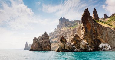 Kırım Yarımadası 'ndaki resim gibi bir dağ sırası, sönmüş antik bir volkan. Kara Dag (Black Mount), Koktebel kıyı kasabası. Dünyada eşi benzeri olmayan bir yer. Dünyanın güzelliğini ve vahşi yaşamını keşfedin..
