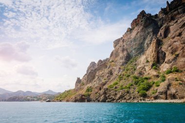 Kırım Yarımadası 'ndaki resim gibi bir dağ sırası, sönmüş antik bir volkan. Kara Dag (Black Mount), Koktebel kıyı kasabası. Dünyada eşi benzeri olmayan bir yer. Dünyanın güzelliğini ve vahşi yaşamını keşfedin..