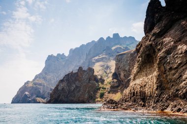 Kırım Yarımadası 'ndaki resim gibi bir dağ sırası, sönmüş antik bir volkan. Kara Dag (Black Mount), Koktebel kıyı kasabası. Dünyada eşi benzeri olmayan bir yer. Dünyanın güzelliğini ve vahşi yaşamını keşfedin..
