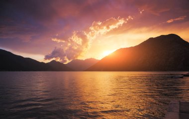 Güneş ışınları ve karanlık uğursuz gökyüzü tarafından aydınlatılan kırmızı canlı bulutlar. Harika bir doğal altyapı. Doğanın fenomeni. Resim gibi ve muhteşem bir sabah sahnesi. Güzellik dünyasını keşfedin