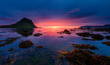 Akşam Kirkjufell volkanı Snaefellsnes yarımadasının kıyısında. Kirkjulsfoss 'un yeri. Tipik İzlanda sahnesi. Dünyada eşi benzeri olmayan bir yer. Duvar kağıdının harika bir görüntüsü. Dünyanın güzelliğini keşfedin.