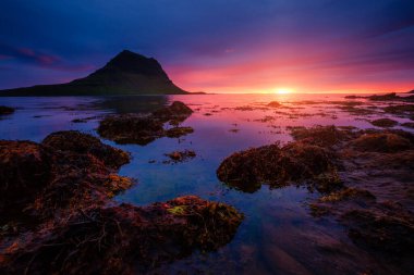 Akşam Kirkjufell volkanı Snaefellsnes yarımadasının kıyısında. Kirkjulsfoss 'un yeri. Tipik İzlanda sahnesi. Dünyada eşi benzeri olmayan bir yer. Duvar kağıdının harika bir görüntüsü. Dünyanın güzelliğini keşfedin.