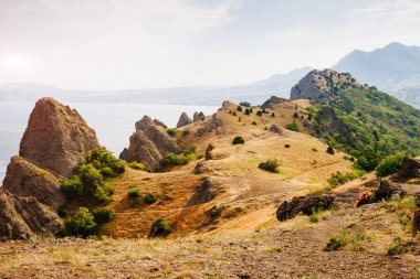 Kırım Yarımadası 'ndaki resim gibi bir dağ sırası, sönmüş antik bir volkan. Kara Dag (Black Mount), Koktebel kıyı kasabası. Dünyada eşi benzeri olmayan bir yer. Dünyanın güzelliğini ve vahşi yaşamını keşfedin..