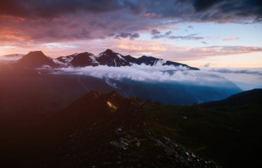 Alacakaranlıktaki güneşli tepelere bakmak. Dramatik bir akşam sahnesi. Grossglockner High Alpine Yolu, Avusturya. Avrupa. İklim değişikliği. Popüler turist eğlencesi. Dünyanın güzelliğini keşfedin
