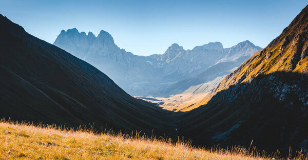 Необычный альпийский диапазон при солнечном свете. Местонахождение Juta village - Chaukhebi, Georgia country, Europe. Главный Кавказский хребет. Приключенческий отпуск. Живописный образ концепции походов. Откройте для себя красоту земли.