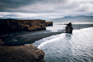 Kirkjufjara plajı ve Arnardrangur uçurumunun manzarası. Myrdal Vadisi, Atlantik Okyanusu, Vik Köyü, İzlanda, Avrupa. Güzel doğa manzarasının manzarası. Toprağın güzelliğini keşfedin.