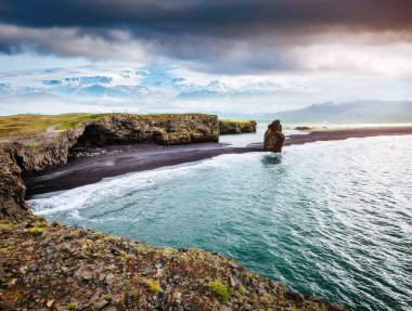 Kirkjufjara plajı ve Arnardrangur uçurumunun manzarası. Myrdal Vadisi, Atlantik Okyanusu, Vik Köyü, İzlanda, Avrupa. Güzel doğa manzarasının manzarası. Toprağın güzelliğini keşfedin.