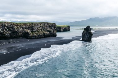 Kirkjufjara plajı ve Arnardrangur uçurumunun manzarası. Myrdal Vadisi, Atlantik Okyanusu, Vik Köyü, İzlanda, Avrupa. Güzel doğa manzarasının manzarası. Toprağın güzelliğini keşfedin.