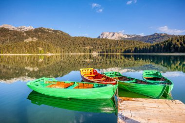 Kara Göl ve ahşap teknelerin muhteşem manzarası. Konum Ulusal Parkı Durmitor, Karadağ, Balkanlar, Avrupa. Egzotik doğa manzarasının manzarası. Muhteşem bir yaz sahnesi. Toprağın güzelliğini keşfedin.
