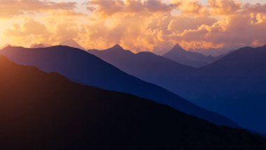 Alacakaranlıktaki büyük tepelere bir göz atalım. Yer Yukarı Svaneti, Gürcistan ülkesi, Avrupa. Kafkasya sırtı. Vahşi bölgenin manzaralı görüntüsü. Toprağın güzelliğini keşfedin. Etkileyici macera duvar kağıtları.