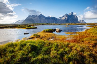 Güneşli bir günde güzel bir dağ manzarası. Stoksnes Burnu, Vestrahorn (Batman Dağı), İzlanda, Avrupa. İnanılmaz doğa görüntüsü. Yaz sahnesi. Toprağın güzelliğini keşfedin
