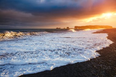 Reynisfjara plajının ve güneşli dalgaların destansı manzarası. Konum Dyrholaey Burnu, Atlantik Okyanusu, Vik Köyü, İzlanda, Avrupa. Güzel doğa manzarasının manzarası. Toprağın güzelliğini keşfedin.