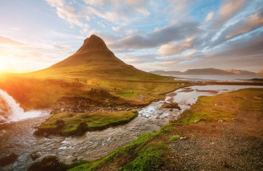 Kirkjufellsfoss şelalesiyle nefes kesici gün batımı. İzlanda, Avrupa 'da. Turist çekiminin manzaralı görüntüsü. Seyahat konsepti. Dünyadaki en iyi yer. Toprağın güzelliğini keşfedin.