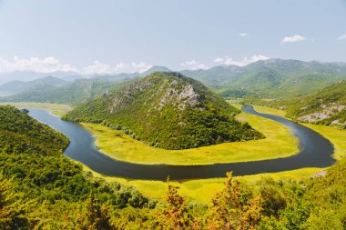 Rijeka Crnojevica 'nın dağlardan akan hava manzarası. Konum Ulusal Park Skadar Gölü, Karadağ, Balkanlar, Avrupa. Popüler seyahat merkezinin manzaralı görüntüsü. Toprağın güzelliğini keşfedin.