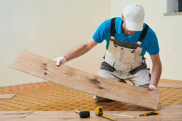 家庭乙烯地板 在家庭楼层翻新时 工人用填充物安装木板 — 图库照片