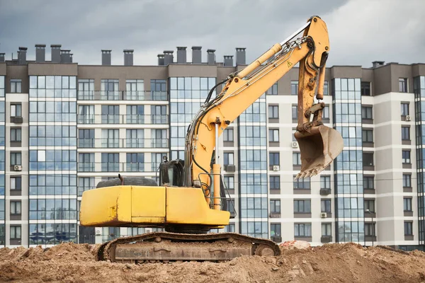 都市不動産開発 現代のアパートの前に立つ建設機械掘削機 — ストック写真