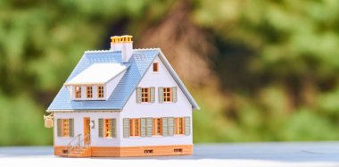 Ev bakımı, ev kiralama ya da emlak geliştirme ve emlak yatırım konsepti. Minyatür ölçekli ev modeli.