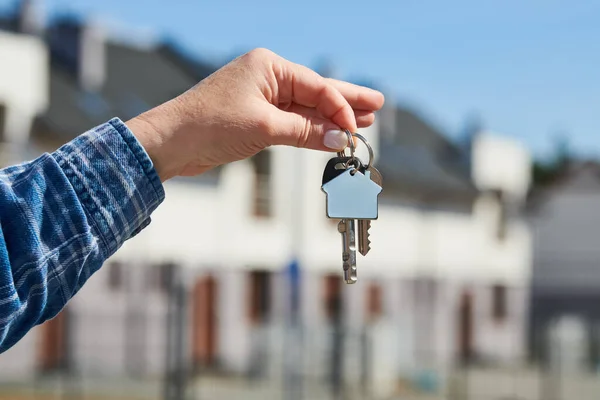 Hand Hält Hausschlüssel Schlüsselanhänger Vor Einem Neuen Zuhause Bauprojekt Umzug lizenzfreie Stockbilder