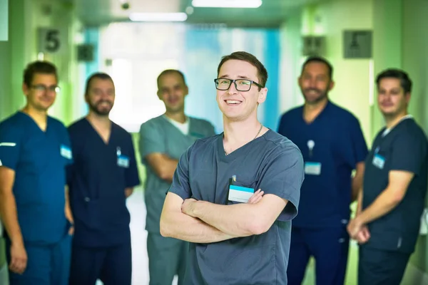 Tıp Cerrahlarından Oluşan Bir Ekip Hastane Koridorunda Kameraya Bakıyor — Stok fotoğraf