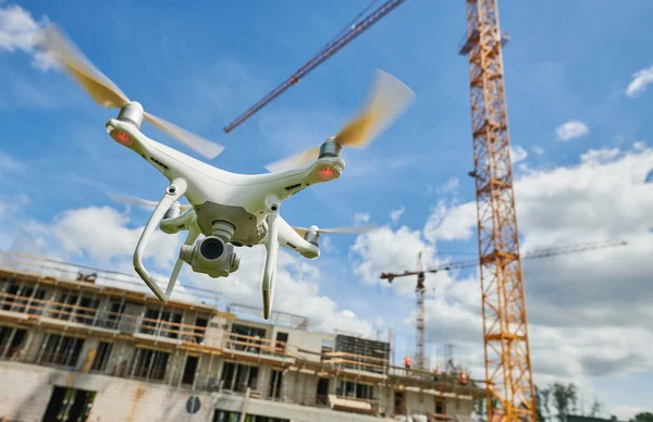 Drone flying at construction site. Video surveillance or industrial safety inspection at building area