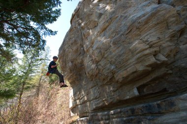 Kaya yüzeyinden inen erkek dağcının yan görüntüsü