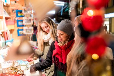 Innsbruck 'ta Noel pazarında alışveriş yapan mutlu genç kadınlar, birlikte zaman geçiren gülümseyen kızlar ve Avusturya' da sıcak kıyafetler alanlar, yaşam tarzı ve kültür kavramları.