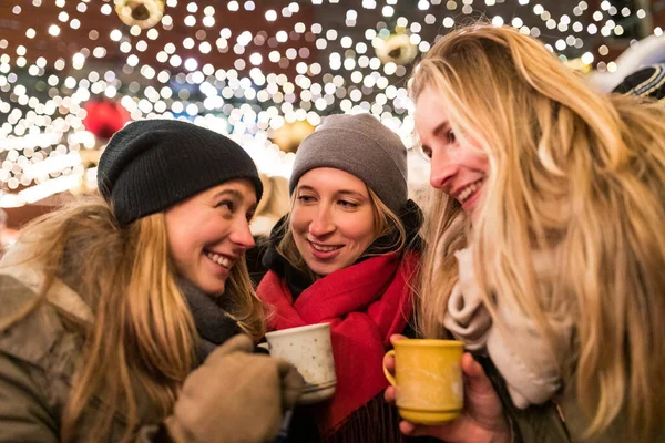 在因斯布鲁克的圣诞市场上 快乐的年轻女性喝着满满一杯含酒精的葡萄酒 在奥地利 微笑的女孩在寒冷的夜晚享受着热饮保暖 生活方式和文化观念 — 图库照片