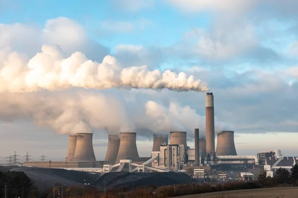 Coal power station with smoke coming out of cooling towers and chimney in England, UK - Power and electricity production with environment issues